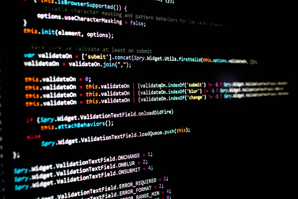 javascript regels code in een bibliotheek voor website applicatie. Script taal in een software ontwikkeld voor internet en webistes. Zwarte achtergrond met gekleurde lijnen van code. Javascript-instructies - Foto, afbeelding