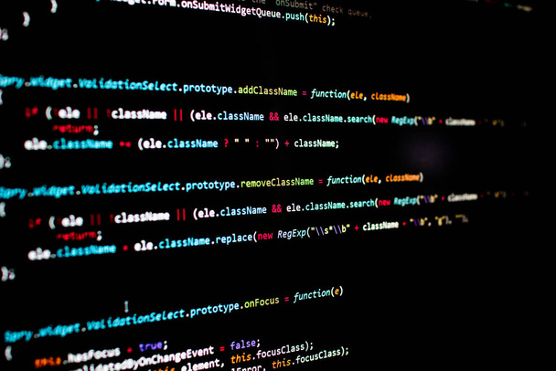 javascript regels code in een bibliotheek voor website applicatie. Script taal in een software ontwikkeld voor internet en webistes. Zwarte achtergrond met gekleurde lijnen van code. Javascript-instructies - Foto, afbeelding