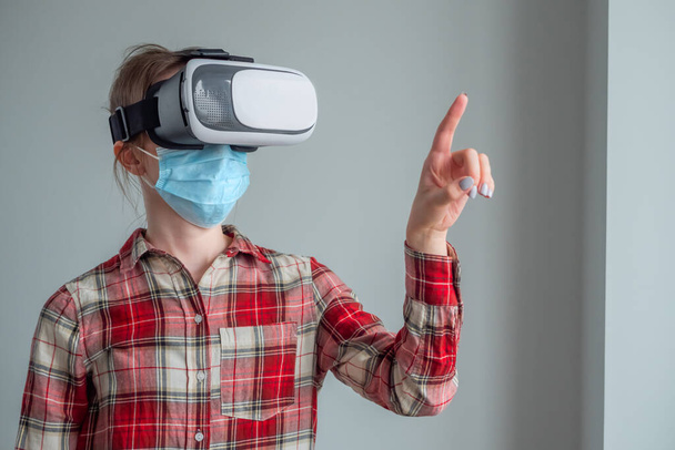 Orvosi maszkot és virtuális valóság headsetet viselő fiatal nő - VR koncepció - Fotó, kép