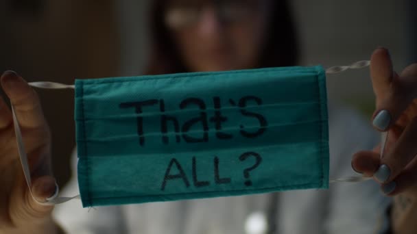 Green protective face mask with question sign Thats All holding in female doctors hands. Nobody knows if it is the end of covid19 pandemic or not. Stop coronavirus in the world.  - Filmagem, Vídeo