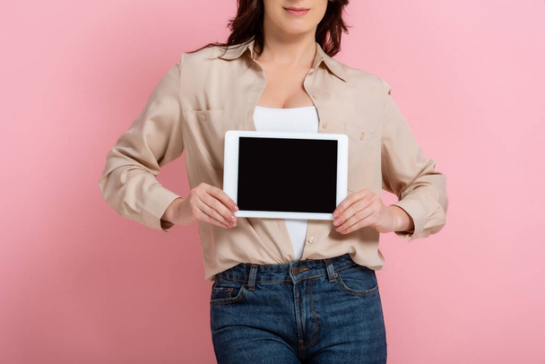 Cropped view of woman holding digital tablet on pink background, concept of body positive  - Photo, Image