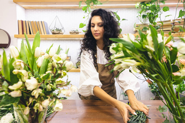 Attractive young woman florist is working in a flower shop. - Valokuva, kuva