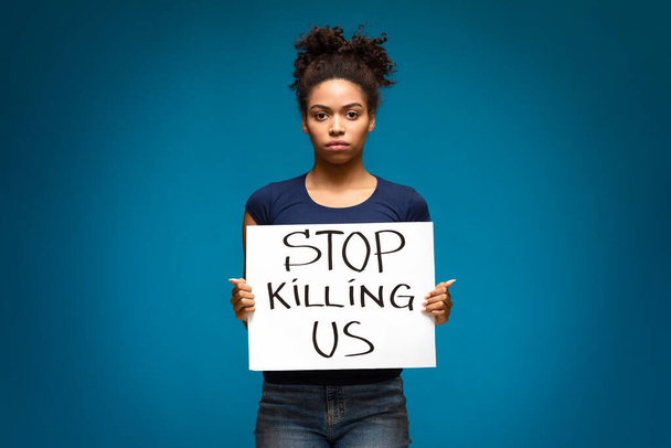 Africano americano mulher de pé com bandeira Pare de nos matar
 - Foto, Imagem