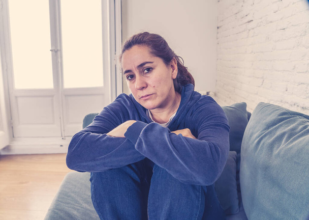 Young lonely attractive latin woman crying on couch feeling sad tired and worried suffering depression isolated at home. Mental Health and lockdown, stress, unemployment and heartbroken concept. - Fotoğraf, Görsel