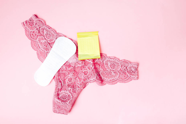 Sanitärserviette mit Unterwäsche auf rosa Hintergrund, Gesundheitsfürsorge, monatlicher Schutz, zuverlässiger Freund. - Foto, Bild