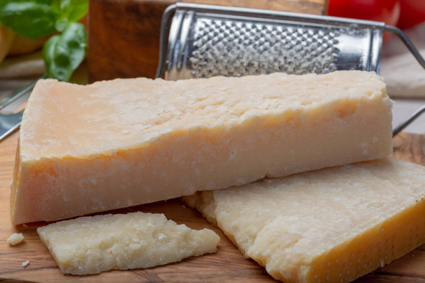 Eredeti olasz sajt, érlelt parmezán tehéntej sajt, Parmigiano-Reggiano darabok közelről - Fotó, kép