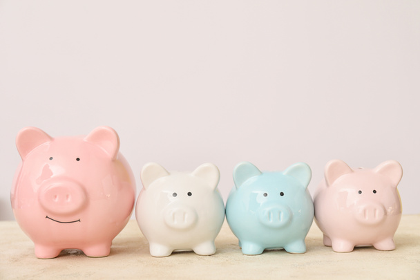 Piggy banks on table against light background - Photo, Image