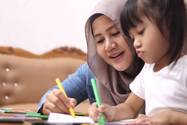 Asiatique mère musulmane dessin avec sa fille, mère célibataire enseignant bébé fille, concept de famille heureuse   - Photo, image