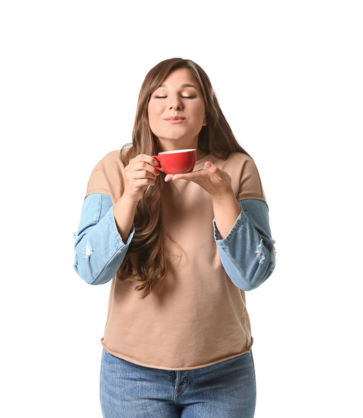Νεαρή γυναίκα πίνει ζεστό καφέ σε λευκό φόντο - Φωτογραφία, εικόνα