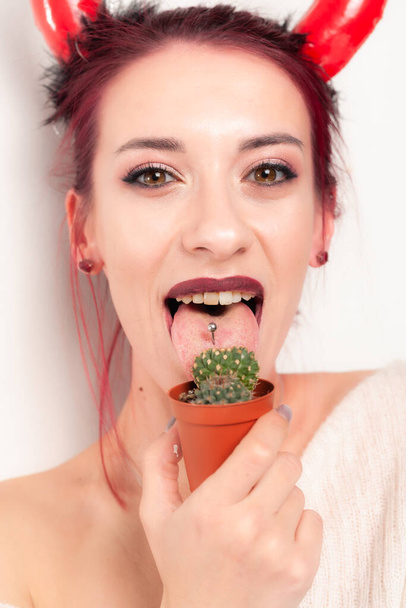 Zabawna dziewczyna liże kaktusa. - Zdjęcie, obraz