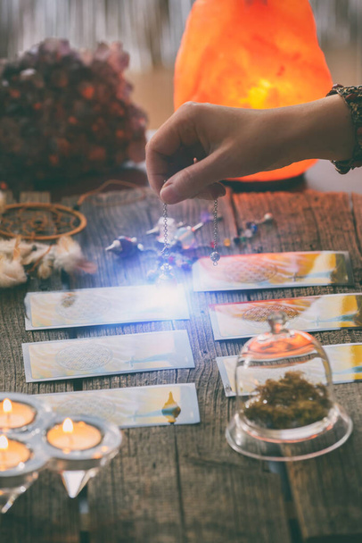Fortune teller holding a pendulum over tarot cards - Zdjęcie, obraz