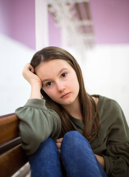 Adolescente deprimido infeliz con la cara en las manos sentado en el banco
 - Foto, Imagen