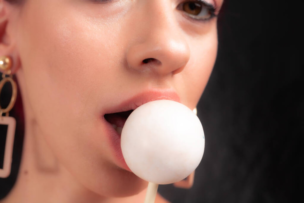 Primer plano de labios femeninos y dulces. Chica comiendo caramelos en un palo. Hermosos labios
. - Foto, Imagen