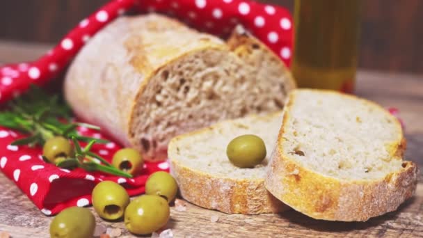 Świeży chleb krojony, oliwki i oliwa z oliwek na stole. - Materiał filmowy, wideo