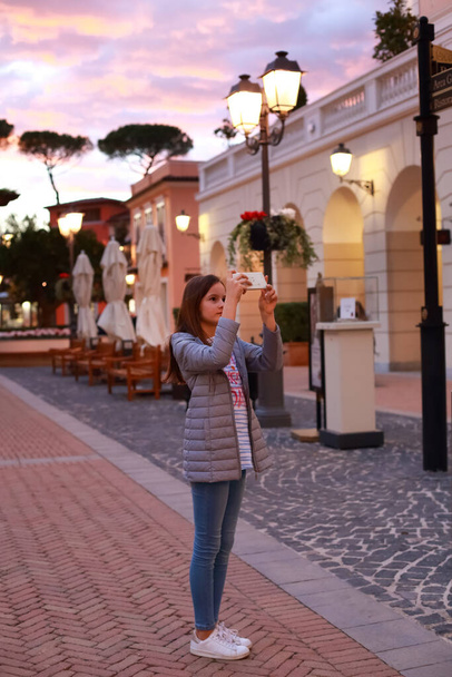 Adolescente marche et prendre une photo dans une vieille ville - Photo, image