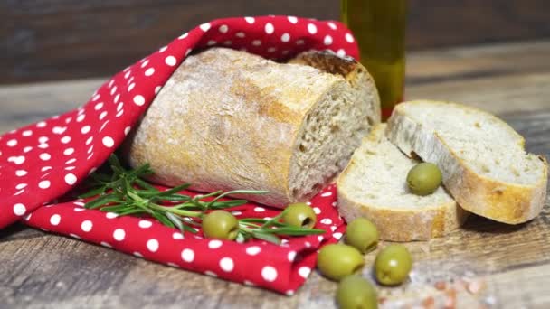 Świeży chleb krojony, oliwki i oliwa z oliwek na stole. - Materiał filmowy, wideo