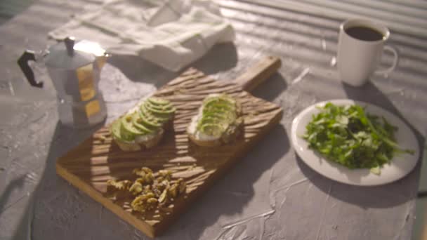 Gezond ontbijt concept. Toast met avocado crème op houten plank - Video