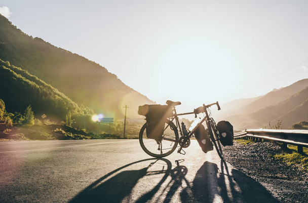 Arka planda bisiklet turu yaparken yolda arabasız bisikletsiz görüntüler var. Kırsalda bisiklete binmek. Kazkbegi Ulusal Parkı. Georgia.2020 - Fotoğraf, Görsel