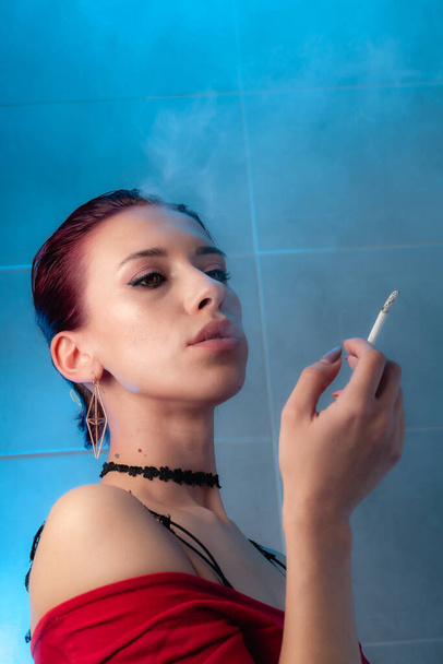 Το κορίτσι καπνίζει ένα τσιγάρο. Κυρά με αυτοπεποίθηση. - Φωτογραφία, εικόνα