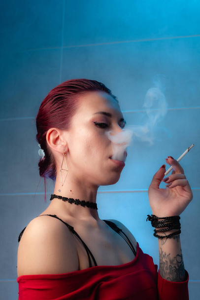 Girl smokes a cigarette. Confident lady. - Photo, image