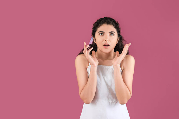 Shocked young woman on color background - Foto, Imagen
