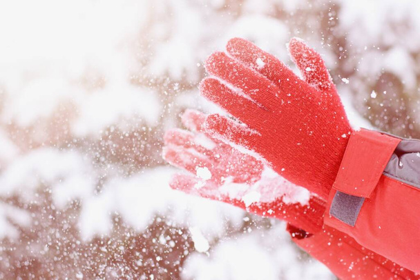 Eller kırmızı eldivenlerle taze karla oynuyor. - Fotoğraf, Görsel