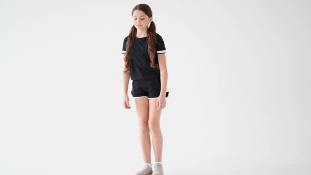 Sportif belle adolescente en vêtements de sport faire de l'exercice de planche contre fond dégradé gris en studio - Séquence, vidéo