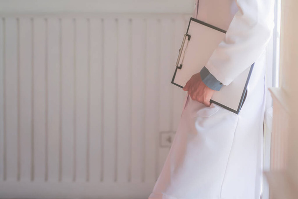 Blurred images of doctors carrying clipboards with a history of patients awaiting diagnosis The doctor holds the patient's medical history after examination and diagnosis for correct treatment. - Photo, Image