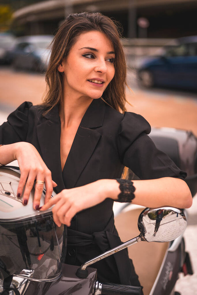 aantrekkelijke jonge vrouw poseren op motor  - Foto, afbeelding
