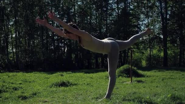 Kobieta uprawia jogę w parku - Materiał filmowy, wideo