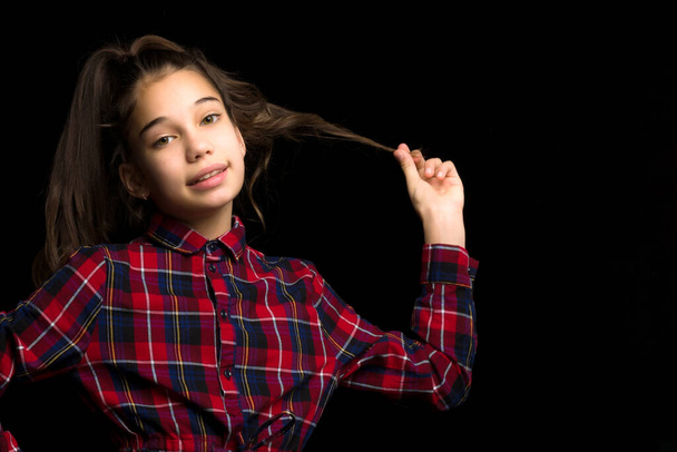 A beautiful little girl straightens her hair on her head. - Zdjęcie, obraz