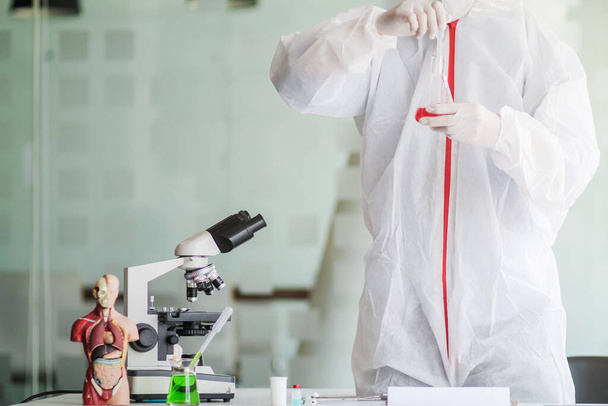 Медична команда носила захисний костюм коронавірусу та гумові рукавички для вивчення кованої крові коронавірусу-19 та дослідження вакцини для запобігання коронавірусної крові-19 для зупинки епідемії
. - Фото, зображення