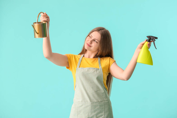 Junge Frau mit Gießkanne und Wassersprüher auf Farbhintergrund - Foto, Bild