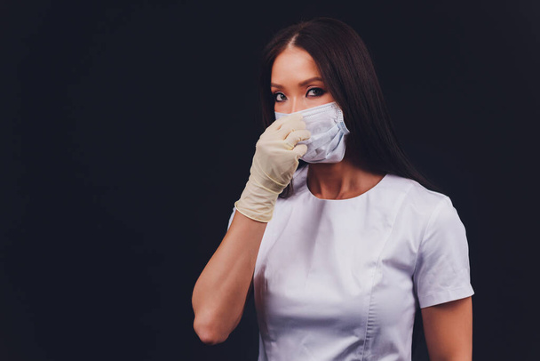 Close up woman portrait, Young woman wearing home made hygienic face medical mask to prevent infection, illness or flu and 2019-nCoV. Black background. Protection against disease, coronavirus. - 写真・画像