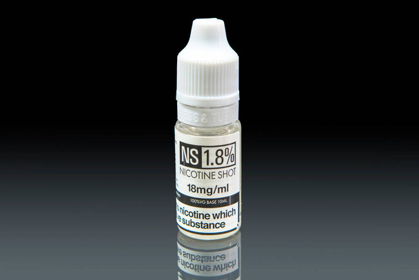 Szczepionka nikotynowa z gliceryną roślinną stosowana do uzupełniania e-płynów, które są umieszczane w e-papierosach podczas wapowania. - Zdjęcie, obraz