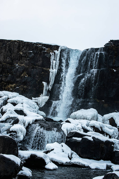 Photo d'une impressionnante cascade entourée de neige en Islande - Photo, image