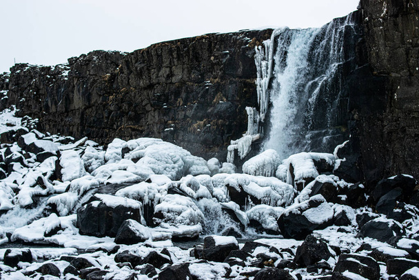 アイスランドの雪に囲まれた印象的なカスケードの写真 - 写真・画像