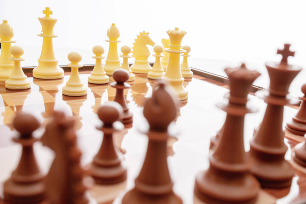 Bild von Schachfiguren auf einem Schachbrett. Weltschachtag. Internationaler Schachtag. 20. Juli. Seitenansicht. Nahaufnahme. Weißer Hintergrund. Fokus auf die Rückennummern - Foto, Bild