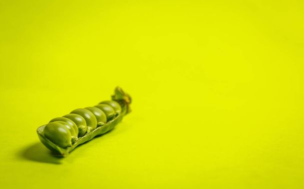 Ripe green peas on a green background - Фото, изображение