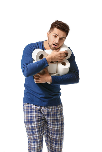 Fiatal férfi sok tekercs WC-papír fehér háttér - Fotó, kép