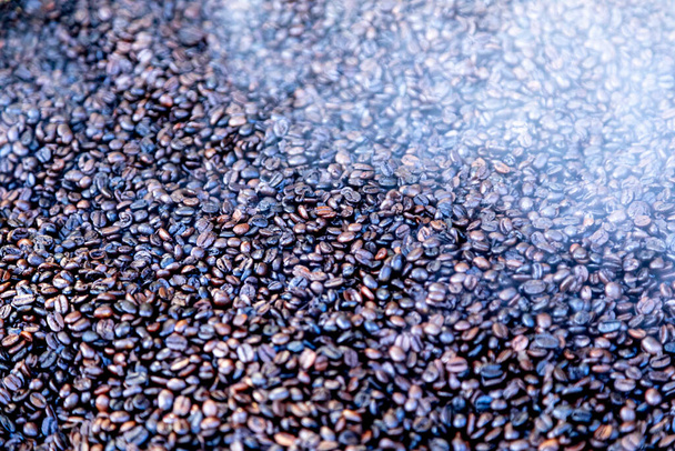 Roasted coffee beans, just came out of the fire, hot, smoke coming out. - Photo, Image