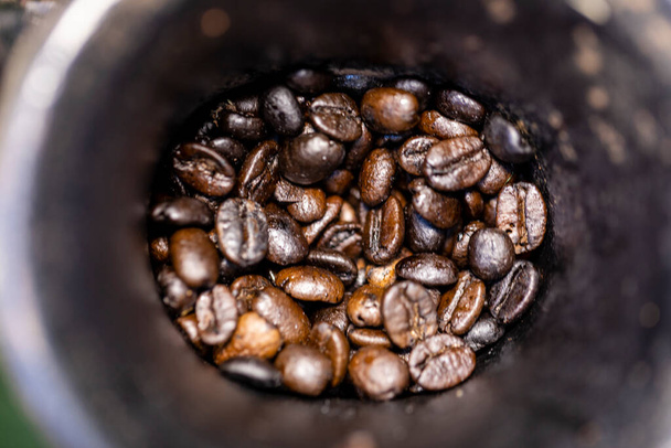 Roasted coffee beans inside in the manual grinder. - Photo, Image