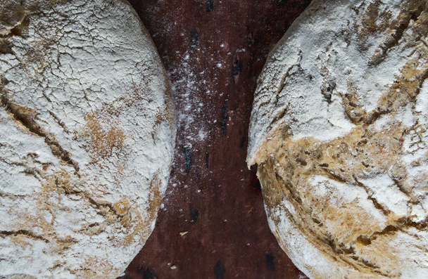 Fresh home baked artisan bread in wicker basket on wood table - Φωτογραφία, εικόνα