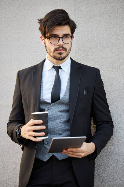Young Businessman using a tablet pc outside wearing a classic suit - Fotoğraf, Görsel