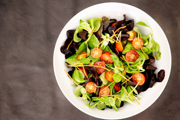 Alkuperäinen salaatti sekoitettuna pinaatti tomaatit, ateria ruoka herkullinen ruokavalio terveellistä. - Valokuva, kuva
