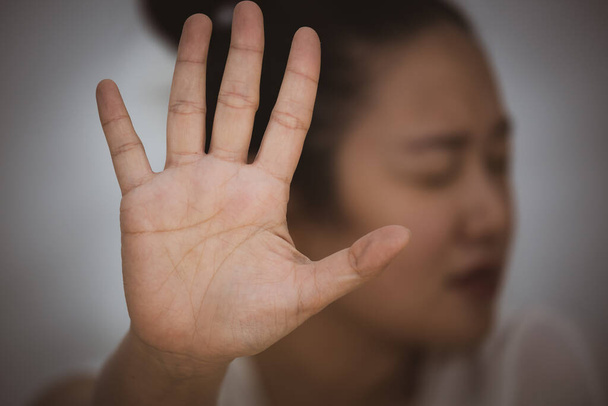 Egy nő képe, aki kezet emel, hogy betiltsa vagy eltakarja az arcát, hogy ellenállást mutasson, és abba akarja hagyni a fogantatás erőszakosságát a fehér hátterű nők ellen.. - Fotó, kép