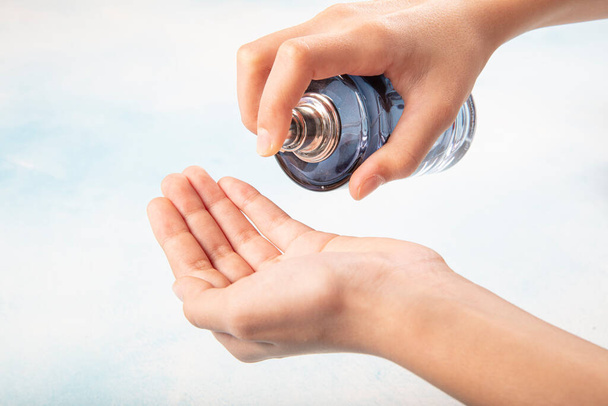 Kişisel el temizliği için ellerine parfüm döken biri.. - Fotoğraf, Görsel