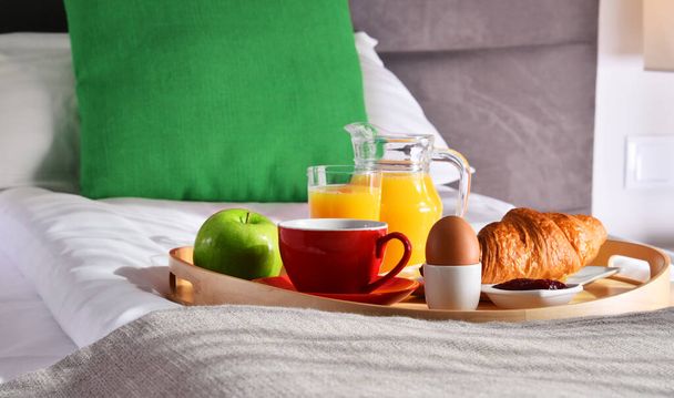 Breakfast on tray in bed in hotel room.  - Photo, Image