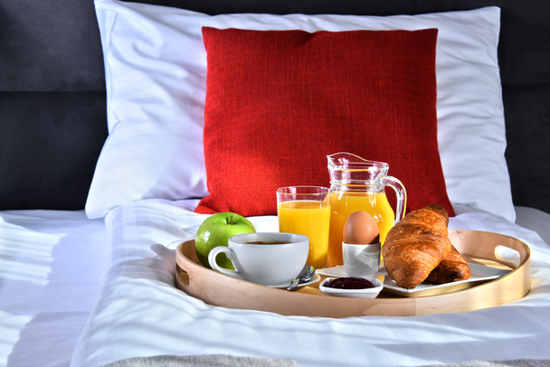 ホテルの部屋のベッドでトレイで朝食。.  - 写真・画像
