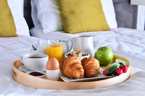Breakfast on tray in bed in hotel room.  - Φωτογραφία, εικόνα